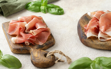 prosciutto ham on a wooden board with basil - 788519678
