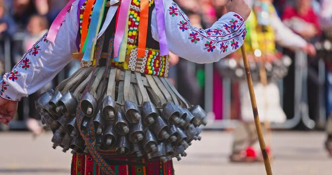 Bulgarian Kukers with bells and traditional costumes, masked people kukeri dancing in masquerade festival Kukerlandia, Yambol, Bulgaria