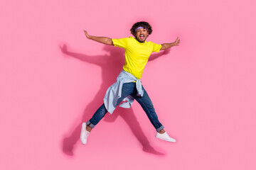 Photo of cheerful optimistic man wear stylish yellow clothes jump up good mood fly air isolated on...