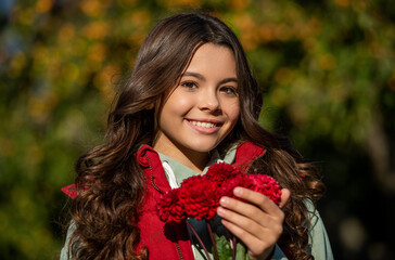 cheerful teenager girl with fall flowers bouquet. teenager girl with fall flowers outside. - 788530481