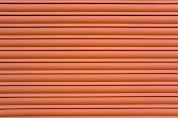 Background from a red painted roller shutter of a shop