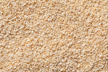 Belboula, dried barley grits full frame close up as background