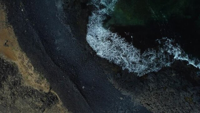 beautiful scenic sea view from above of the turquoise sea and waves and rocks, splashes of waves are found on the rocks.drone view of a turning speedboat in azure water
