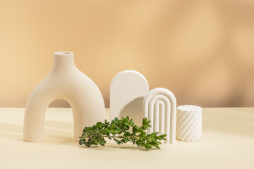 Still life with a modern vase, plaster figurines and a boxwood branch. Product presentation. Copy...