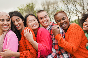 Group of multiracial women hugging each other outdoor - Diverse female friends and community concept - International women day