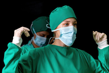 nurse help surgeon wearing medical uniform to protect body in operation. surgical doctor preparing...