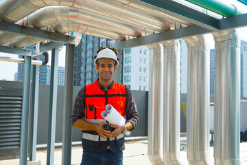 Foreman engineer wearing reflective jacket, engineering helmet, holding walkie-talkie and...