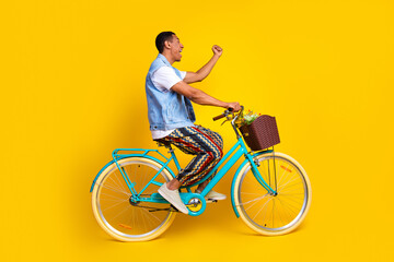 Full length photo of overjoyed guy dressed jeans waistcoat driving cycle yell look empty space...