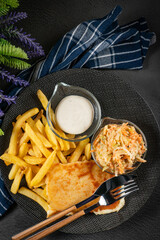 Appetizing fried cheese served with french fries, tartar sauce and salad