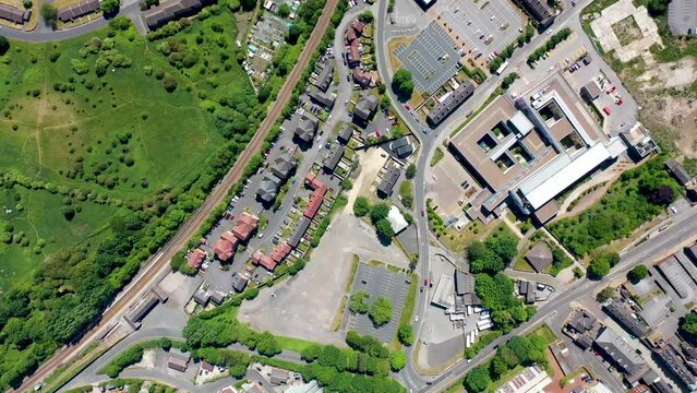 Top down aerial footage of the Pontefract Hospital located in the village of Pontefract in Wakefield, West Yorkshire in the UK on a sunny summers day showing the Hospital, Car Park and housing estate