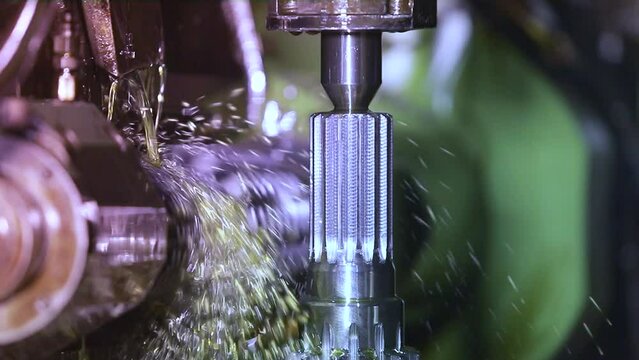 CNC grinding milling machine. CNC turning center. CNC machining high precision turning throwing coolant liquid on metal component during shaping forming process using machining center