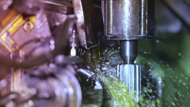 Close up of CNC grinding milling machine. CNC turning center. CNC machining high precision turning throwing coolant liquid on metal component during shaping forming process using machining center