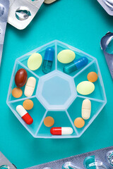 Pillbox with pills and capsules on a tabletop