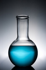 Glass flask placed in a laboratory table with blue liquid