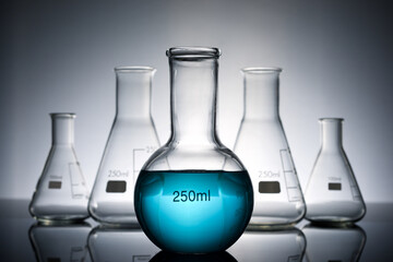 Glass flasks placed in a laboratory table with blue liquid