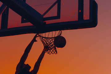 Silhouette of Basketball Player Scoring at Sunset