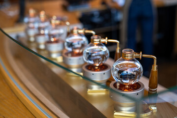 An array of sophisticated manual coffee brewing stands poised for crafting the perfect cup in a modern cafe setting. - obrazy, fototapety, plakaty