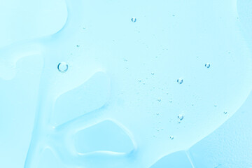 Gel texture of cosmetic products. transparent cream on a soft blue background with bubbles. macro photo. blur and selective focus.