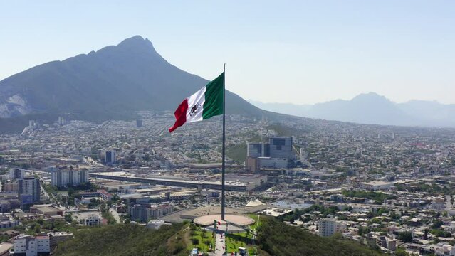 Aerial Forward Shot Of Tall Flag At Mirador Del Obispado On Hill In City Against Sky - Monterrey, Mexico