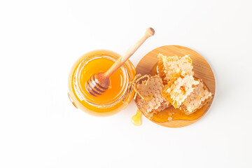 Honey dripping from a wooden honey dipper on white background. Healthy organic food concept. 