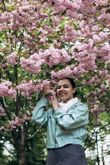 A young beautiful girl is photographed outdoors in a flowering tree