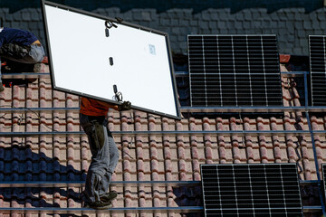 Handwerker mit Solarpanel auf dem Dach