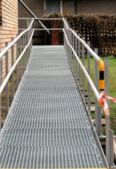 a metal ramp for the disabled and baby carriages at the wall of the building