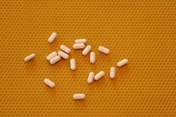 fun spilled medical pills on a yellow beeswax background