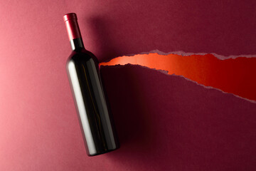Bottle of red wine on a dark red background. - 788607419