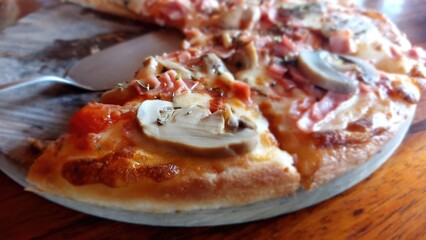 Pizza sliced with mushroom and ham and cheese