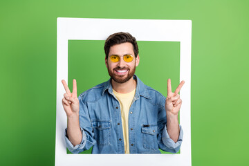 Photo of cheerful friendly guy wear denim jacket tacking photo showing two v-signs empty space...