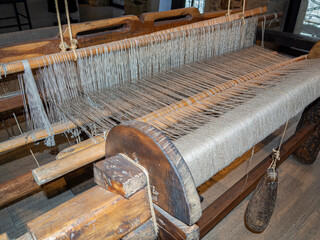 Vista de los hilos de color hueso de un entramado de tejido en un telar antiguo de madera, España,...
