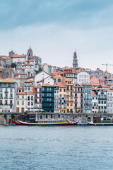 Fototapeta na wymiar Porto, Skyline view of the old town of Portugal on the Douro river. Travel and monuments of Portugal. Old historic houses of Porto. Rows of colorful buildings in traditional architectural style.