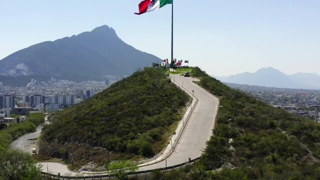 Aerial Ascending Shot Of Tall Flag At Mirador Del Obispado On Hill In City Against Sky - Monterrey, Mexico