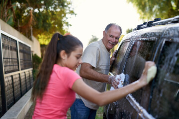 Father, child and car washing for cleaning, learning responsibility and development outdoor. Young...