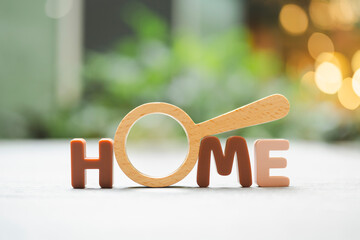 Magnifying glass and looking at HOME text, house selection, real estate concept.