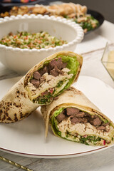 Shawarma chicken roll in a pita with fresh vegetables, cream sauce and Arabic Cuisine: Middle Eastern traditional lunch. It's also Ramadan 