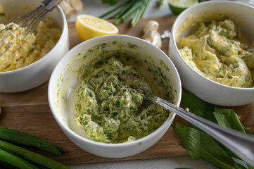 Fresh prepared herb butter on a wooden cutting board.