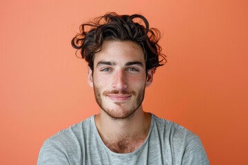 Fototapeta premium A man with a beard is smiling in front of an orange wall