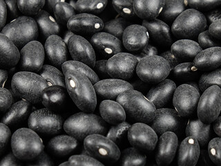 Heap of small black beans shiny black turtle bean, whole legumes black seeds, natural texture background.

