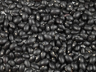 Heap of small black beans shiny black turtle bean, whole legumes black seeds, natural texture background.
