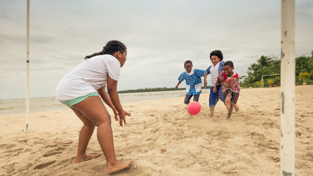 Girl waiting for the ball to reach the goal area to catch it, in a soccer game on the beach. - Powered by Adobe