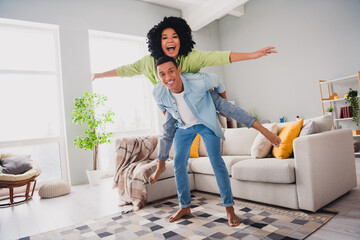 Photo of cool excited couple dressed casual outfits having fun together flying plane wings indoors...