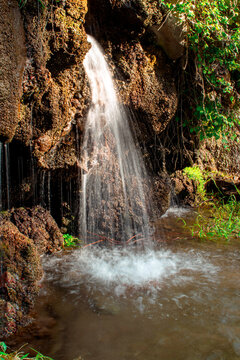 Imagen vertical de una caída de agua tipo cascada ideal para fondos bonitos de la naturaleza 