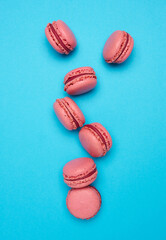 Pink macarons on blue background, top view