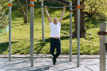 a man works out on a horizontal bar in the open air