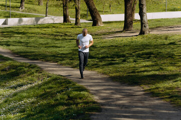 bald man runs in the park. morning run