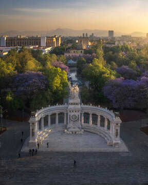 Aerial drone view of Hemiciclo a Juarez, a historic monument with jacaranda trees in Mexico City at sunrise, Mexico.