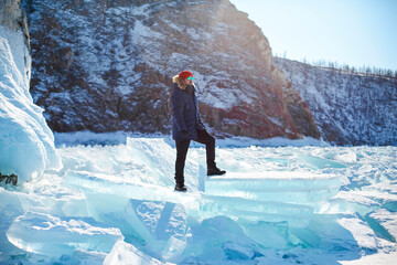 Portrait of the man tourist in red cap and blue jacket wearing sunglasses on ice