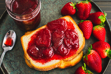 Slice of Toast Covered in Homemade Strawberry Preserves: Sliced and toasted white bread and...